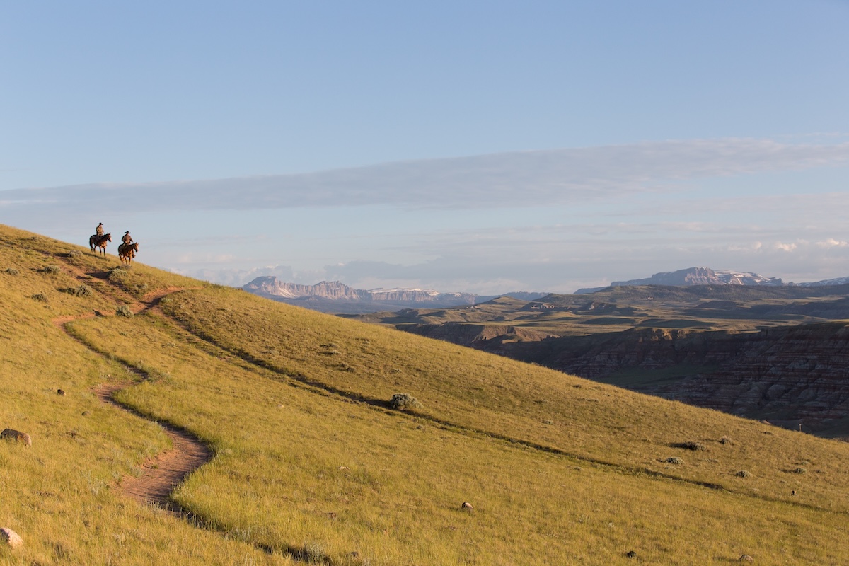 Two riders navigate a hillside trail
